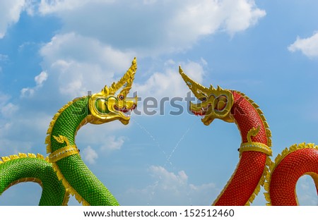 red and green dragon and Naga statue at Thai temple with blue sky and cloud
