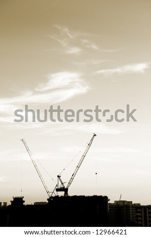 Cranes on construction site (Silhouette)