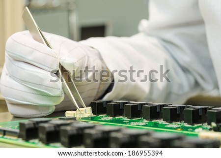 Female hand holding tweezers and installing connector on PCB in turnkey solutions high-tech manufacturing