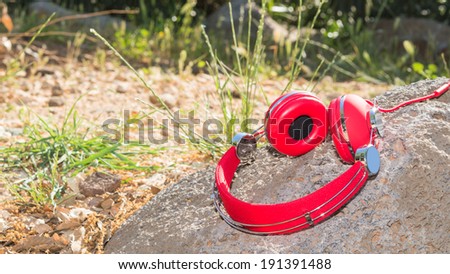 Vivid red wired headphones on the stone with free area for your text