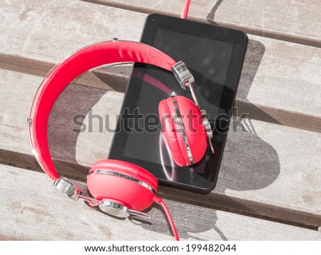 Red colored headphones and tablet PC for distance education or language course learning