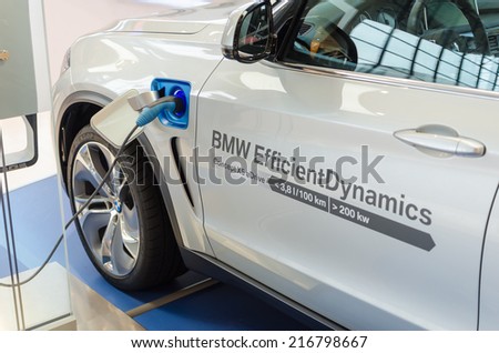 MUNICH, GERMANY - AUGUST 8, 2014: New model of environmentally friendly electric car BMW x5 with hybrid engine at charging station.