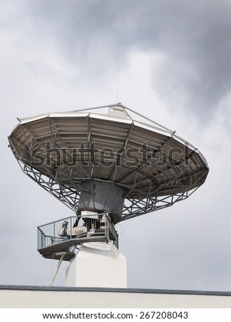 Radiolocator with parabolic satellite radar antenna dish for radio television translation or directional wireless network communication data broadcasting