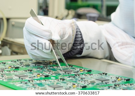 Quality control and assembly of SMT printed components on circuit board in QC lab of PCB manufacturing high-tech factory
