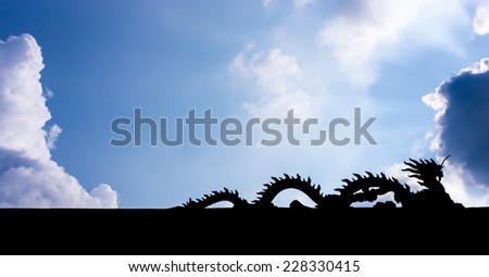 Dragon Silhouette over the roof with the blue sky