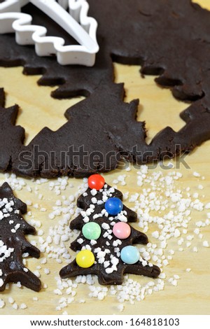 Cooking chocolate Christmas cookies, decorated with large crystals of sugar and sweet confetti. Form cookies.