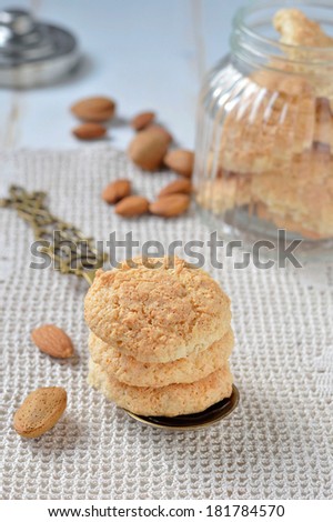 Homemade cookies with almonds and decorations: spoon, glass cookie jar, almond kernels.