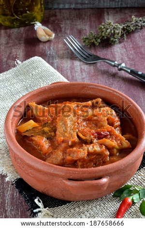 Tripe soup with tomatoes, spicy chili, basil, oregano in in a ceramic bowl. Italian food, South Italy. Closeup.