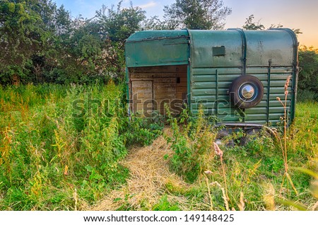 An old horse box/trailer left discarded in a field with hay to feed the horses, UK, England