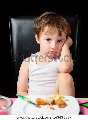 Young boy not happy being told to finish his meal