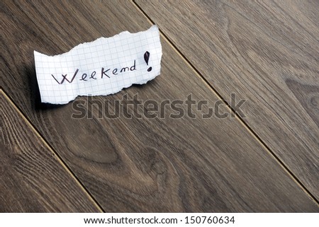 Weekend - Hand writing text on a piece of paper on wood background with space for text