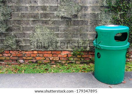 green bin with old brick wall