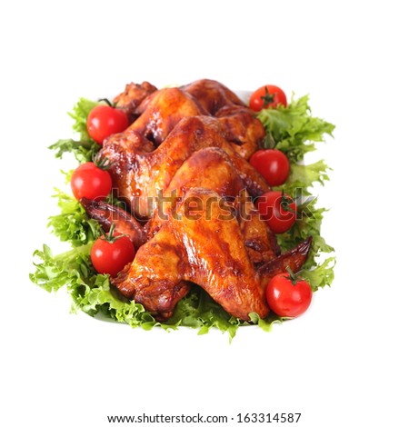 Smoked chicken wings with vegetables on a plate isolated on white