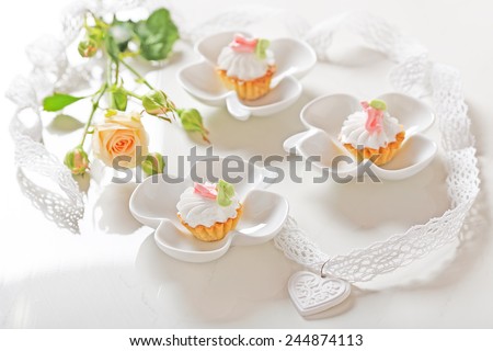 Mini cakes and single rose on a white background
