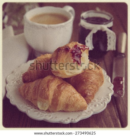 Breakfast with croissants,coffee and jam. Vintage effect, imitation of the old photo, soft focus