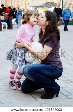 Mother and daughter kissing in the street