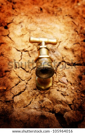 Water faucet on dry soil texture