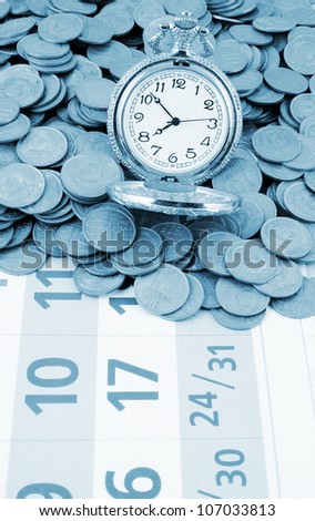 Watch and coins on calendar background