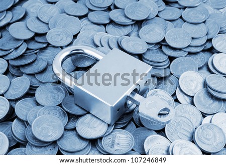 Padlock with key on coins background