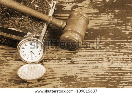 Judge\'s gavel, legal book and watch on old wooden background