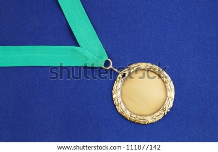 Gold medal with green ribbon on blue velveteen