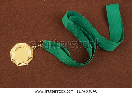 Gold medal with green ribbon on brown velveteen