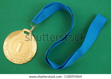 Gold medal with blue ribbon on green velveteen