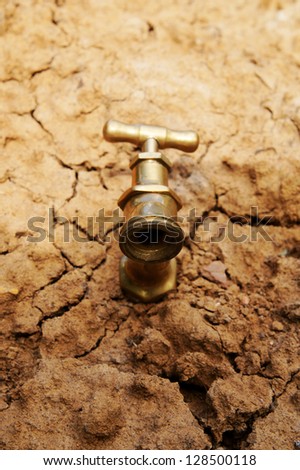Water faucet on dry soil texture