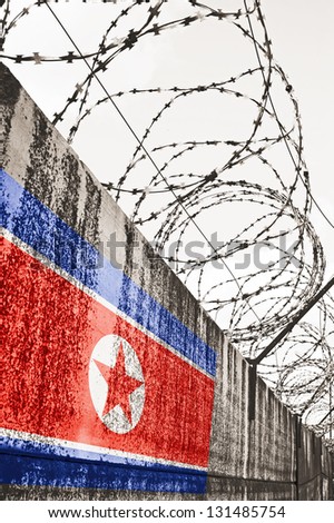 Barbwire and grey wall with North Korea national flag