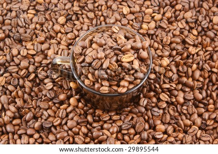 Cup of coffee filled up with beans