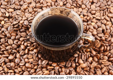 Glass cup of coffee on coffee grains background