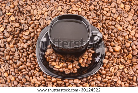 Black cup of coffee on coffee grains background