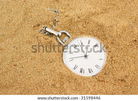 Old pocket watch buried in brown sand