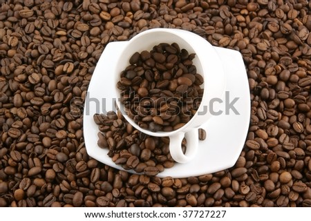 White cup filled up with coffee beans