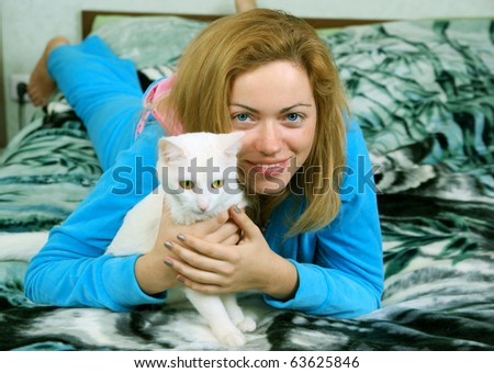 Woman with white cat in the bed