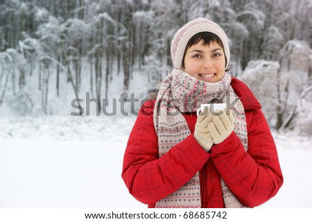 Young woman with cup in winter park