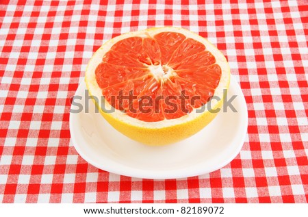 Halved red grapefruit on tablecloth