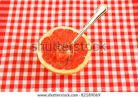 Halved red grapefruit on tablecloth