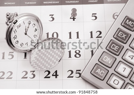 Calculator and watch on calendar page