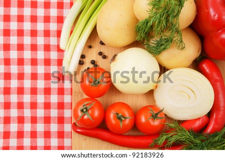 Cutting board with vegetables on tablecloth