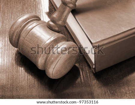 Judge's gavel and legal book on wooden table