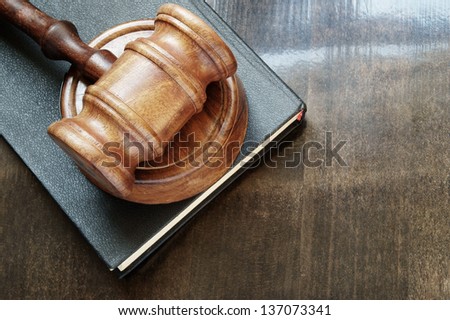 Judge\'s gavel and legal book on wooden table