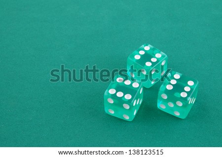 Three dices on green gaming table with space for text