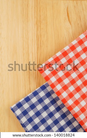 Red and blue checked tablecloth on wooden background