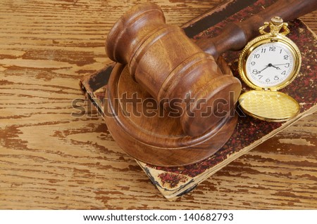 Judge\'s gavel, legal book and watch on old wooden background