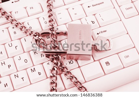 Padlock with key and chain on white computer keyboard
