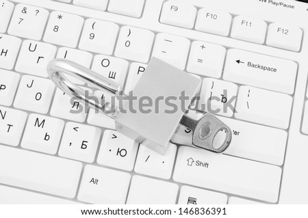 Padlock with key on white computer keyboard