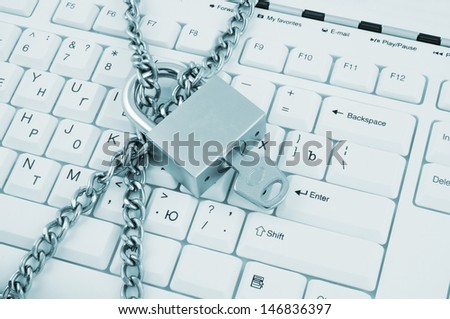 Padlock with key and chain on white computer keyboard