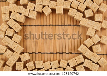 Brown sugar cubes on bamboo background