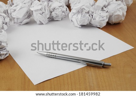 Empty paper, pen and crumpled paper on wooden table